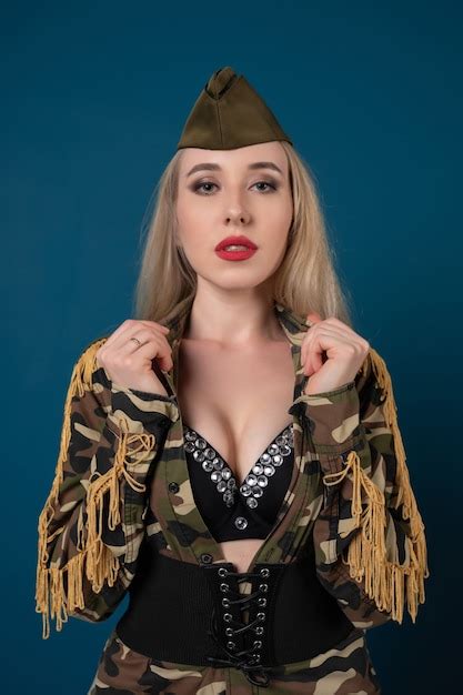 Premium Photo Beautiful Blonde Woman In A Glamorous Military Uniform Posing On A Blue Background