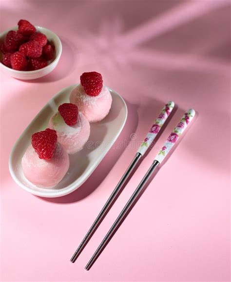 Three Balls Of Raspberry Mochi Decorated With Berries On A Pink