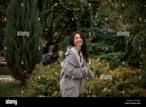 Portrait Of Pretty Asian Kazakh Brunette Woman With Charming Smile Walking Along Outdoors Stock