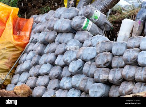 Un mur de soutènement de jardin fait de récipients vides de lait en