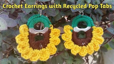 Crochet Earrings With Recycled Pop Tabs Are Hanging On A Tree Branch In Front Of Leaves