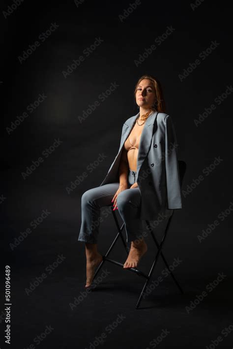 An Incredibly Beautiful Model Girl With Long Blonde Hair In An Unbuttoned Gray Jacket Beige Bra