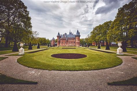 a large building surrounded by lots of trees and lawn with statues in ...