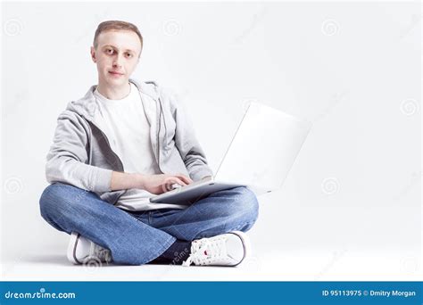 Portret Van Ernstige Knappe Blonde Kaukasische Mensenzitting Met Laptop Op Benen Stock