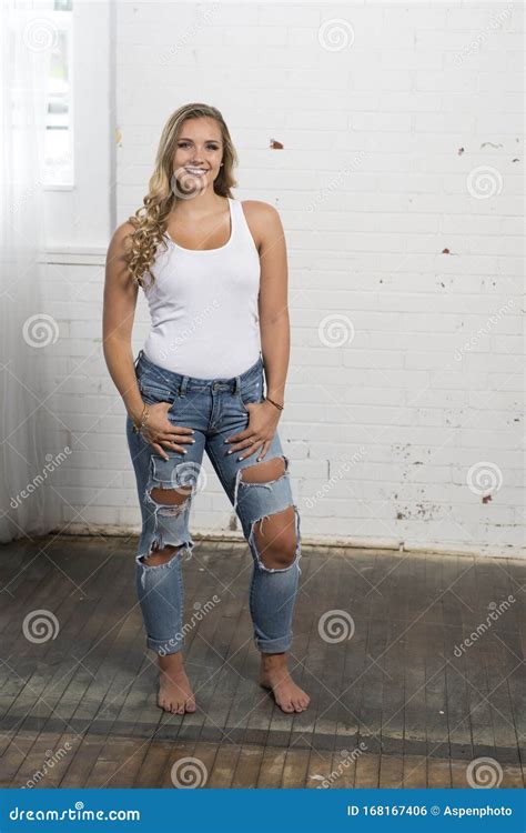La Jeune Femme Blonde Sexy Pose Dans Le Haut De La Cuve Blanc Et Des