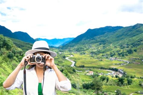 Premium Photo Mature Woman Photographing While Standing On Mountain Against Cloudy Sky