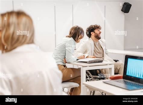 Brunette Female Person Telling Jokes To Her Male Handicapped Colleague In Wheelchair He Burst