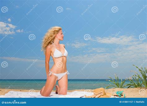 Mujer Joven En El Bikini Blanco Que Sostiene Los Sarong En La Playa Imagen De Archivo Imagen