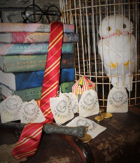 a bird in a cage next to some books and ties on a table with other items