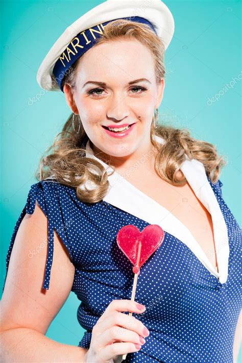 Sexy Blonde Pin Up Girl Wearing Blue Dress With White Dots And Marine Cap Holding Pink Lollypop
