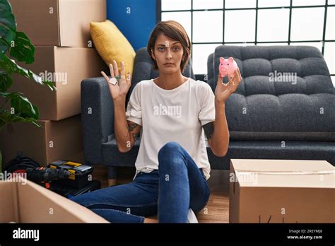 Brunette Woman Holding Keys Of New Home And Piggy Bank Skeptic And