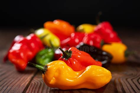 Colored Hot Peppers On A Wooden Surface Stock Image Image Of Orange