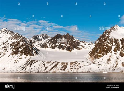 An ice field and snow streaked mountains border Magdalenefjorden ...