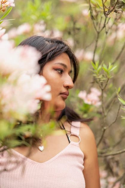 Premium Photo Vertical Portrait A Latina Woman Looking Aside Standing Among Flowering Trees