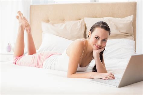 Premium Photo Pretty Brunette Using Laptop On Bed