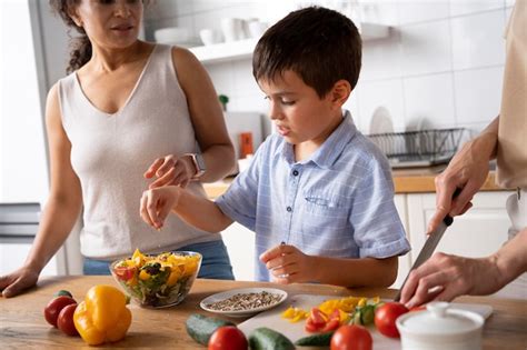 Free Photo Lesbian Couple With Their Son Preparing Some Food