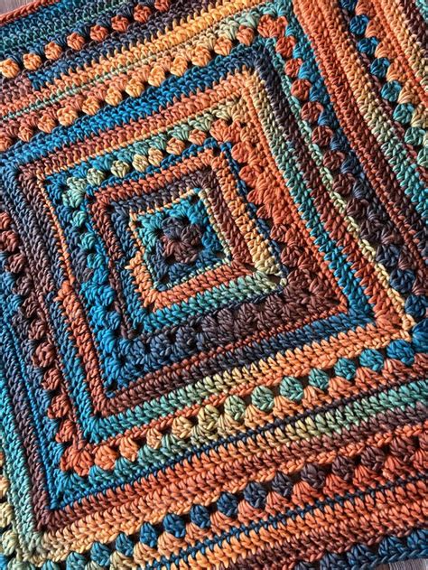 A Crocheted Blanket Is Laying On The Floor