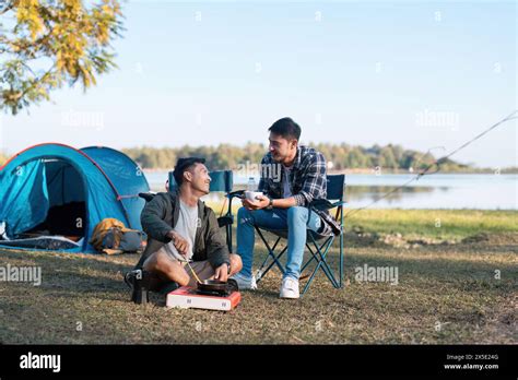 Couple Gay Lgbt Sitting In Camp Cooking And Near River In Mountains Camping Couple Lgbt Concept