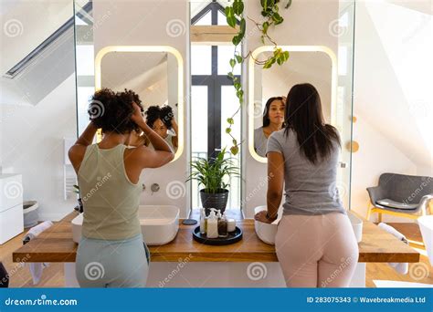 Biracial Lesbian Couple Looking In Mirrors In Bathroom Stock Image Image Of Bisexual Looking