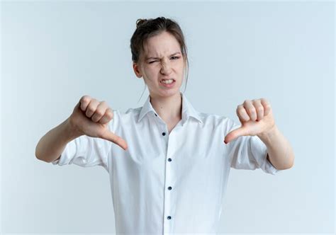 Jeune fille russe blonde agacée pouces vers le bas avec deux mains isolé sur un espace blanc