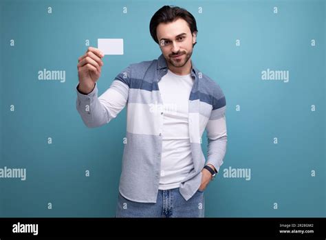 un gars de brunette élégant dans une apparence modèle tient une carte de paie pour faire du