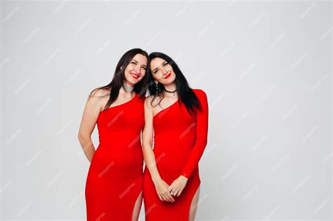 Premium Photo Two Sexy Sisters Twins In Red Dresses