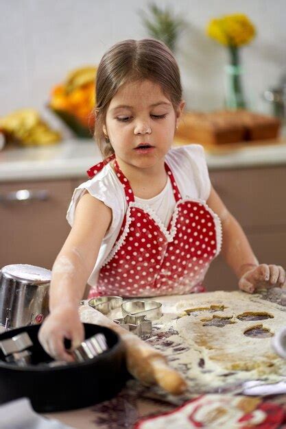 Niña haciendo galletas de jengibre en casa Foto Premium