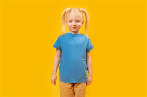 Premium Photo Portrait Of Blonde Girl With Two Ponytails In Blue Tshirt On Yellow Background