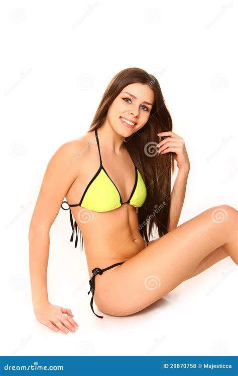 Mujer Joven En Un Bikini Amarillo Que Se Sienta En El Fondo Blanco Foto