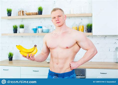 Muscular Man With A Naked Torso In The Kitchen With Fruit Concept Of Healthy Eating Athletic