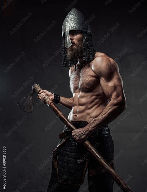 Furious And Muscular Nord Warrior Standing In Dark Background With Naked Torso And With His Two