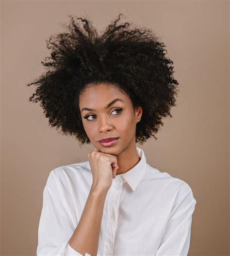 Aproximação de uma jovem afro latina pensando Joy positiva e amando Belo cabelo estilo africano