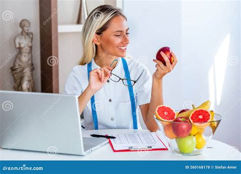 Portrait Of Young Smiling Female Nutritionist In The Consultation Room