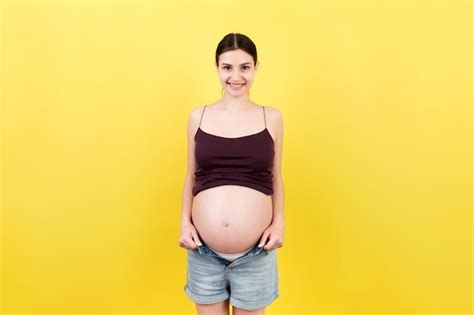 Premium Photo Happy Pregnant Woman In Unzipped Jeans Showing Her Naked Belly At Colorful