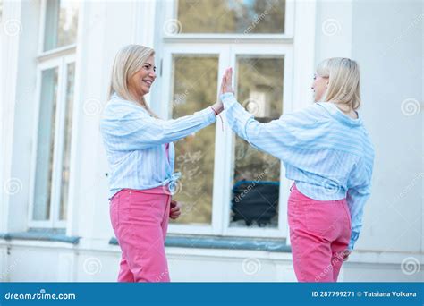 Gestures And Facial Expressions Mom And Adult Daughter Of Blonde Are Dressed Identically