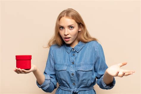 Blonde Frau sich extrem schockiert und überrascht ängstlich und panisch fühlt mit einem