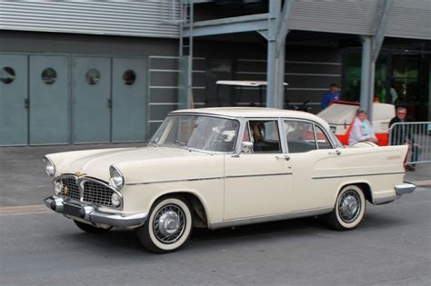 An Old White Car Is Parked On The Street