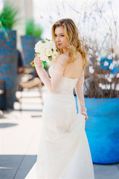 Beautiful Blonde Bride In A Tight Fitting Dress With A Bouquet Stock Image Image Of Bridal