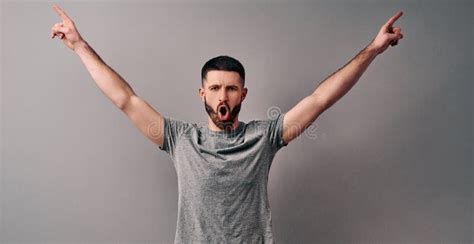 Portrait Of Emotional Handsome Guy Gesturing Victory Sign On Gray