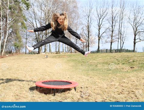 Fille Blonde Sautant Sur Le Trempoline Photo Stock Image Du Exercer Herbe