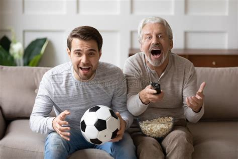 Overjoyed Mature Man With Adult Son Watching Match Together Stock Photo Image Of Grandfather
