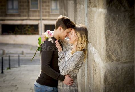 Candid Portrait Of Beautiful European Couple With Rose In Love Kissing