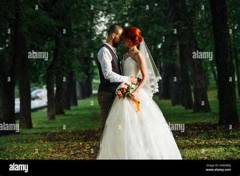 The Bride And Groom Together In The Dark Alley Touching Foreheads Stock