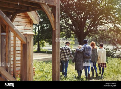 Friends Walking Outside Lakeside Cabin Stock Photo Alamy