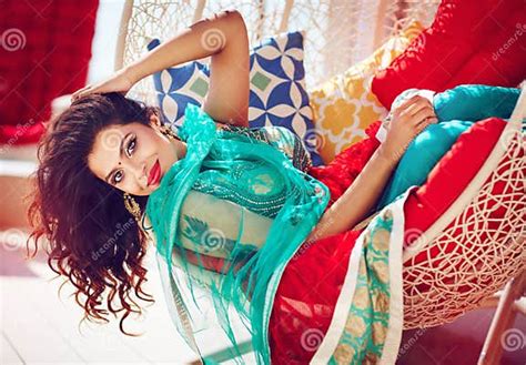 Beautiful Indian Woman In Traditional Dress Relaxing On Sofa Stock