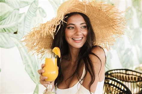 Premium Photo Portrait Of Beautiful Brunette Woman In Straw Hat And Summer Clothes Drinking