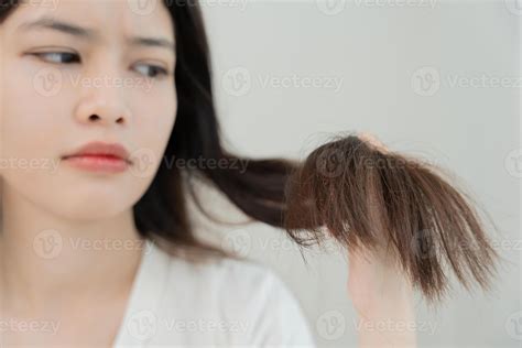 Asia women very sad and upset looking at damaged hair, hair loss, hair