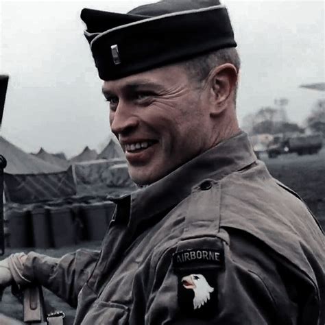 A Man In Uniform Is Smiling For The Camera