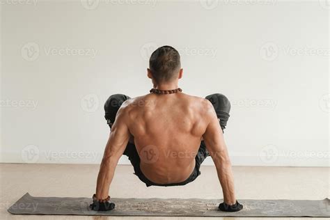 A Man With A Naked Torso Does Yoga Standing On His Hands Indoors Fitness Trainer Stock