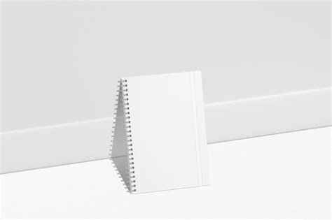 Un Cuaderno De Espiral Blanco Sobre Una Superficie Blanca Foto Premium